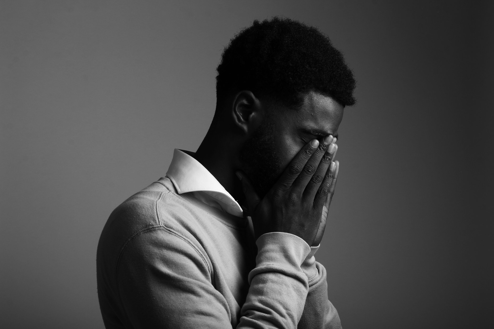 Man Covering His Face with His Hands